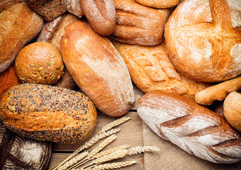 Papier peint photo Boulangerie Tas de pains frais sur bois  © Pineapple studio