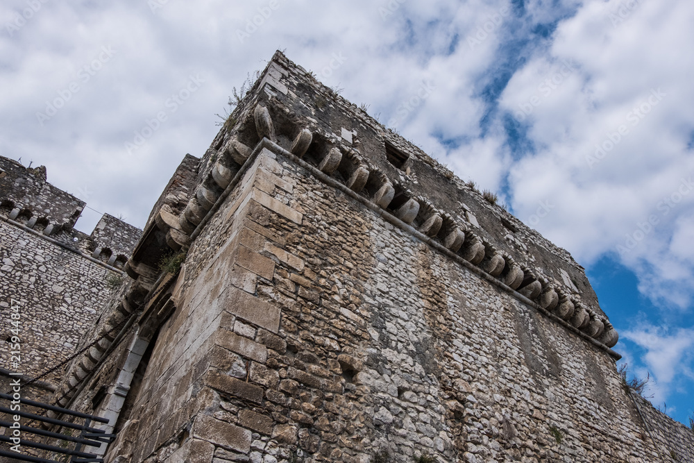 Medieval worn stone castle detail with clouds and blue sky background. Medieval worn stone castle detail with clouds and blue sky background.
