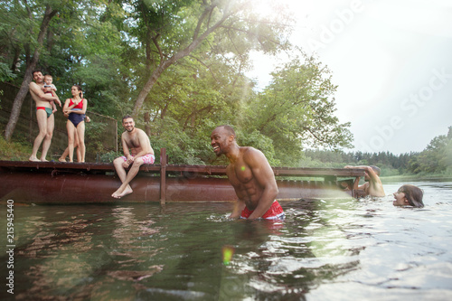 Enjoying river party with friends. Group of beautiful happy young people at the river together photo