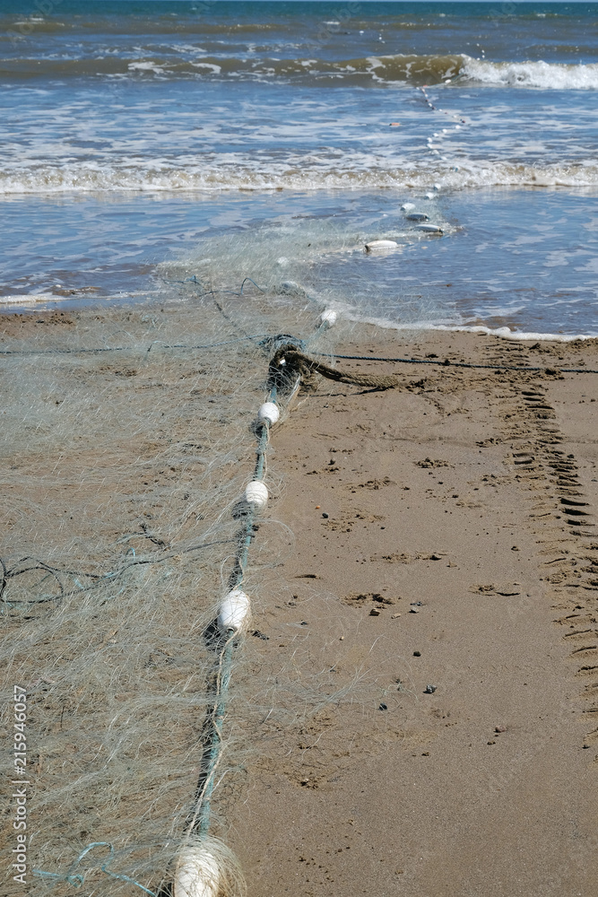 Inshore fishing net set at low tide on beach to catch fish between tides.  Stock Photo