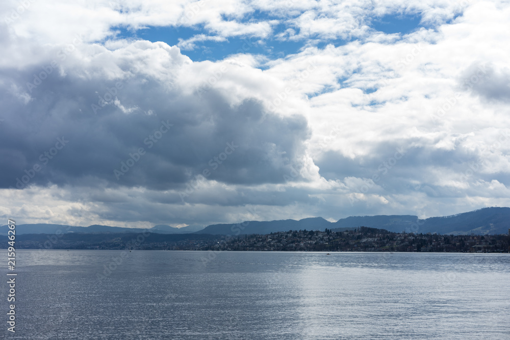 stormy clouds and calm water over lake zurich in switzerland