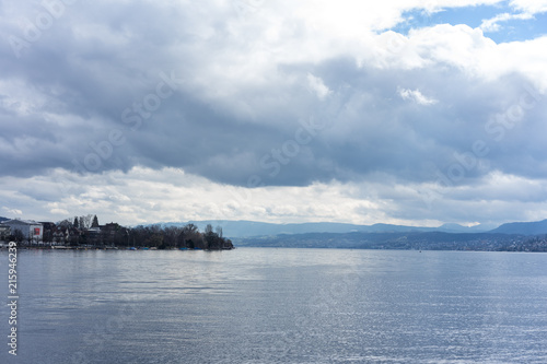 stormy clouds and calm water over lake zurich in switzerland