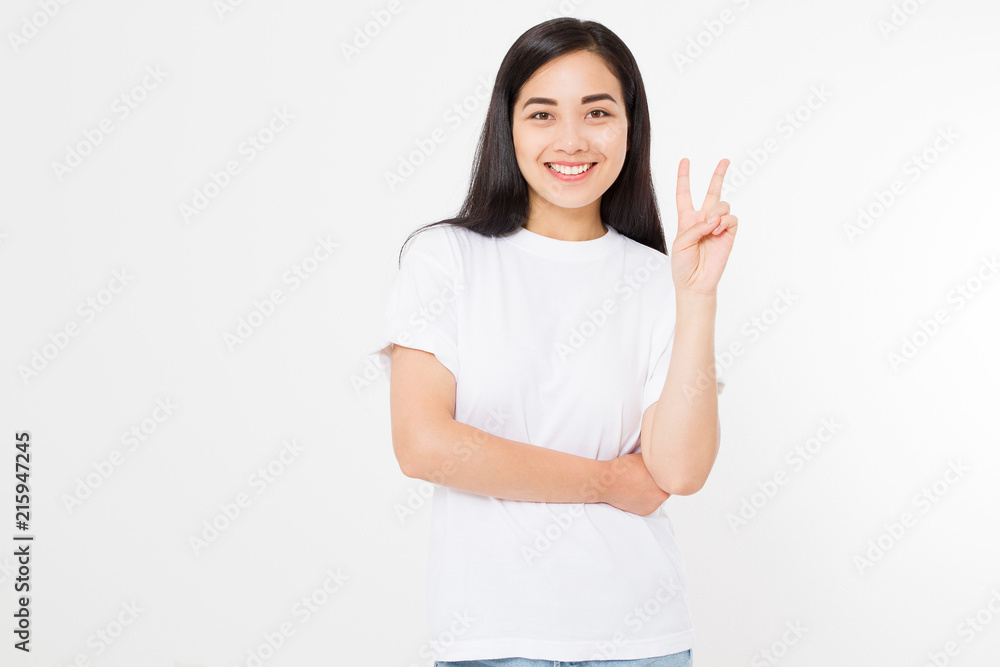 Happy young asian girl showing victory sign isolated on white background. Copy space. Template and blank summer t shirt. Happy young asian girl showing victory sign isolated on white background. Copy space. Template and blank summer t shirt.