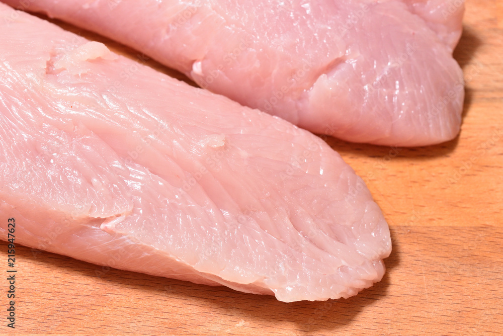 Beautiful and fresh turkey fillet. Fillet of turkey on a wooden cutting board Beautiful and fresh turkey fillet. Fillet of turkey on a wooden cutting board