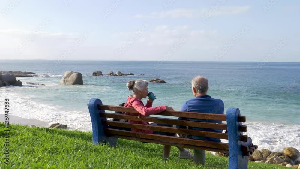 Senior couple resting while on a coastal walk Senior couple resting while on a coastal walk