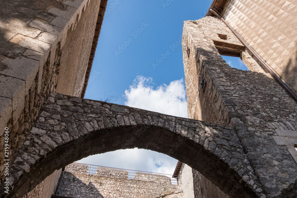 Low angle view of old castle arches and walls from an inside courtyard.