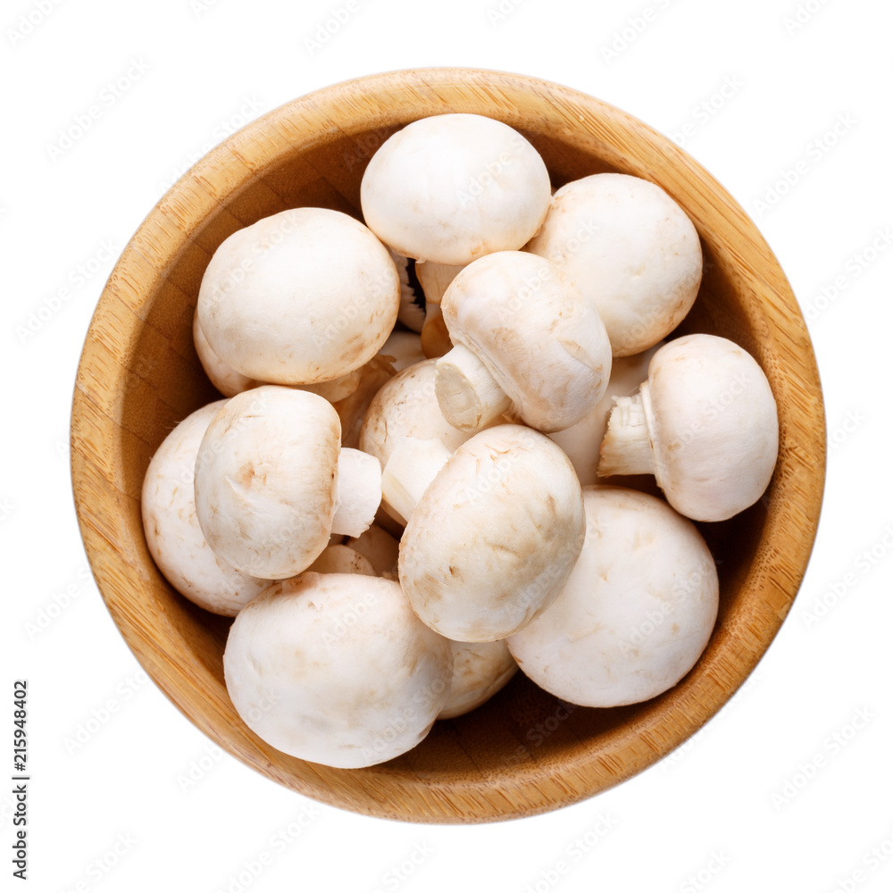 Whole small fresh white champignon mushrooms in wooden bowl isolated on white. Whole small fresh white champignon mushrooms in wooden bowl isolated on white.