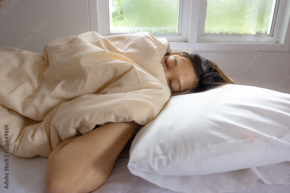 young woman face sleeping while lying in white bed in Sunbeam dawn. young woman face sleeping while lying in white bed in Sunbeam dawn.