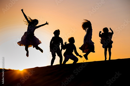 five children jump at sunset