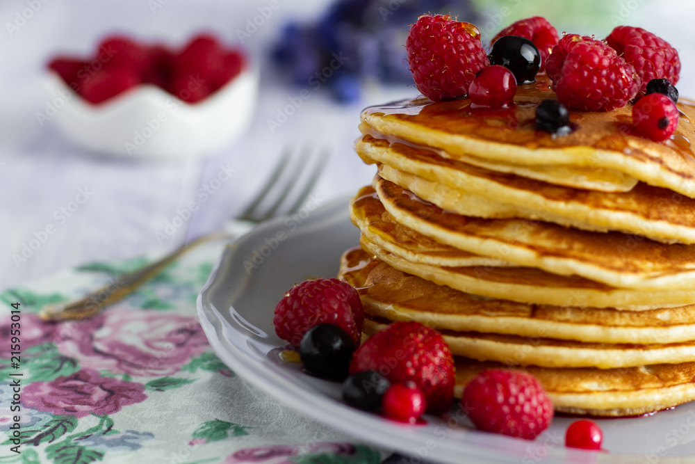 Stack of gold pancakes with berries and honey on wooden background Stack of gold pancakes with berries and honey on wooden background