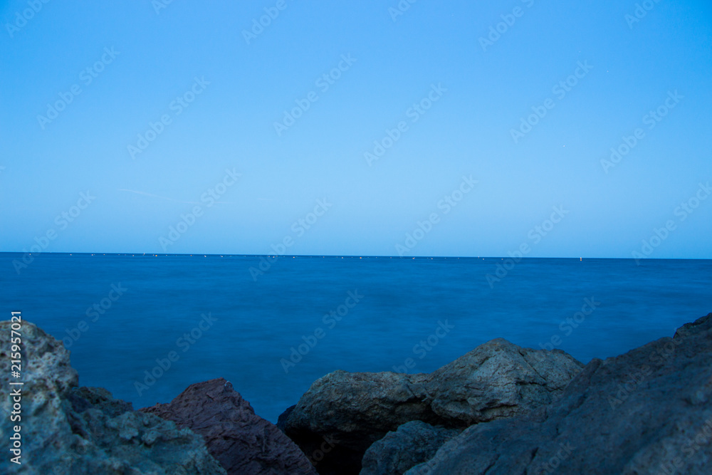 Sunset and the night light in Ravda. Bulgaria. Reflection of light of the city in the sea. Sunset and the night light in Ravda. Bulgaria. Reflection of light of the city in the sea.