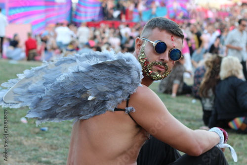 Sexy man with wings and glitter beard in music festival  photo
