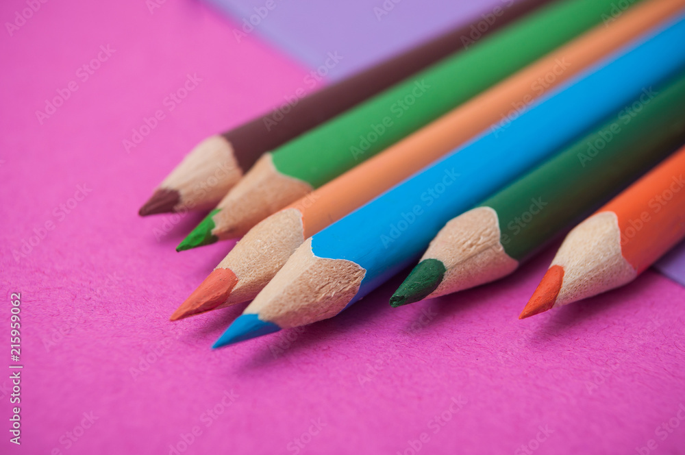 closeup of colouring pencils on color background closeup of colouring pencils on color background