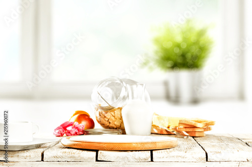 Continental breakfast and blurred background of white window with green plant. Free space for your decoration. 