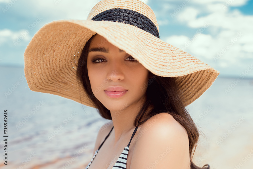 attractive girl posing in swimsuit and straw hat