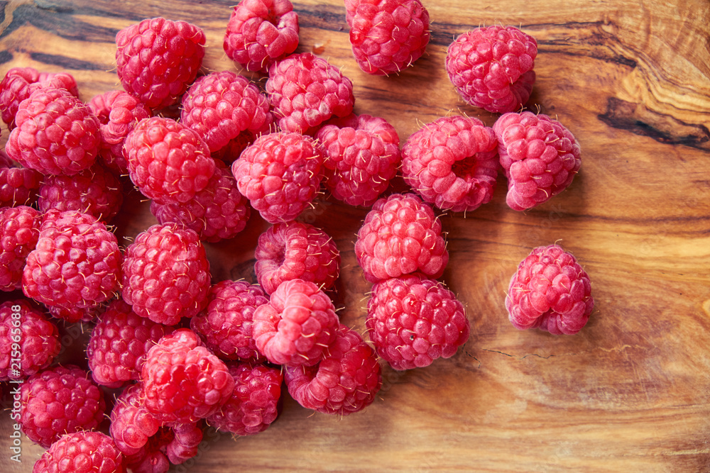 Fresh organic raspberries on black background. berries on a wooden spoon Fresh organic raspberries on black background. berries on a wooden spoon