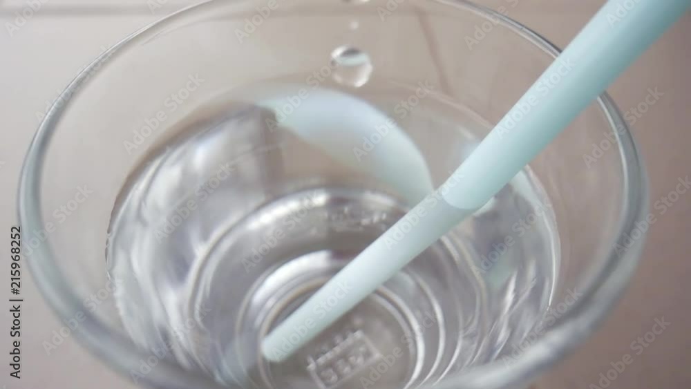 Close up shot of a glass of water with straw standing on a table. Close up shot of a glass of water with straw standing on a table.