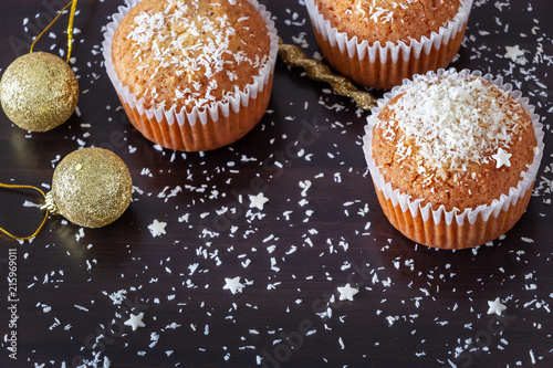 Homemade lemon muffins decorate coconut powder dark wooden background. New year and Christmas concept. Vertical. Selective focus.