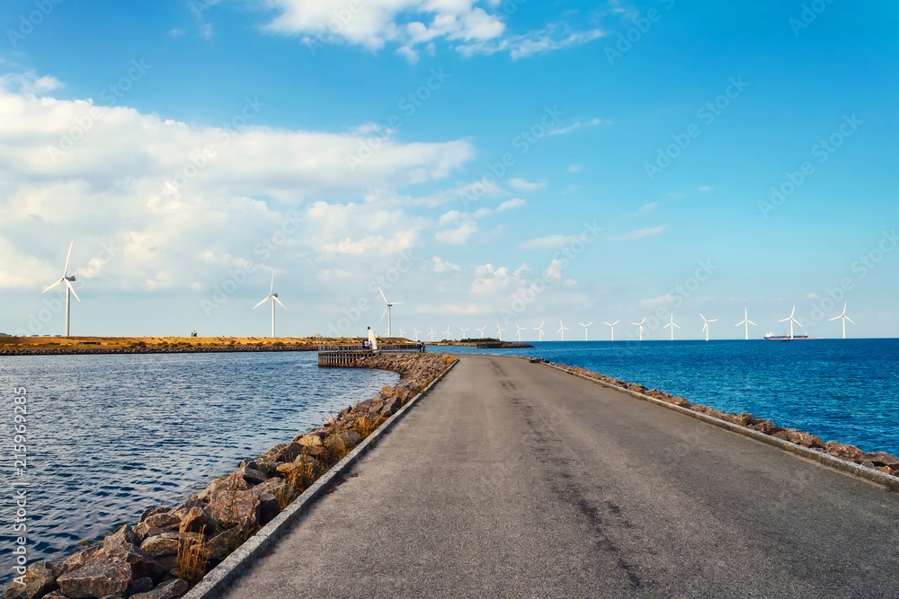 Wind turbines in the sea, on a sunny summer day. Blue sky. Ecological energy. Denmark.