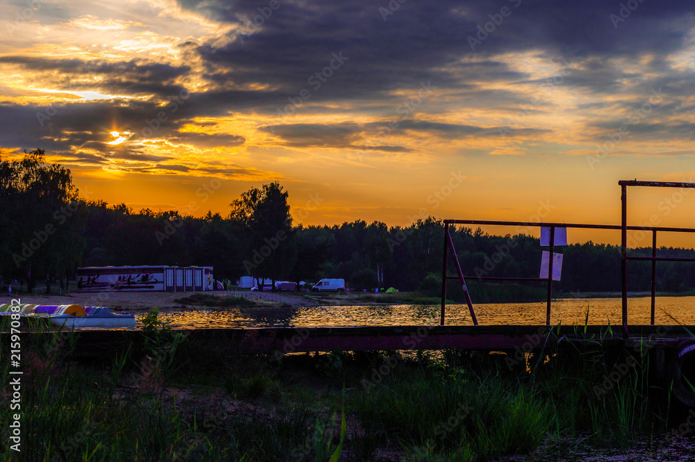 Sunset over the recreational lake, you can see ducks and boats. Beautiful orange colors, big contrast. Holidays and rest. Sunset over the recreational lake, you can see ducks and boats. Beautiful orange colors, big contrast. Holidays and rest.