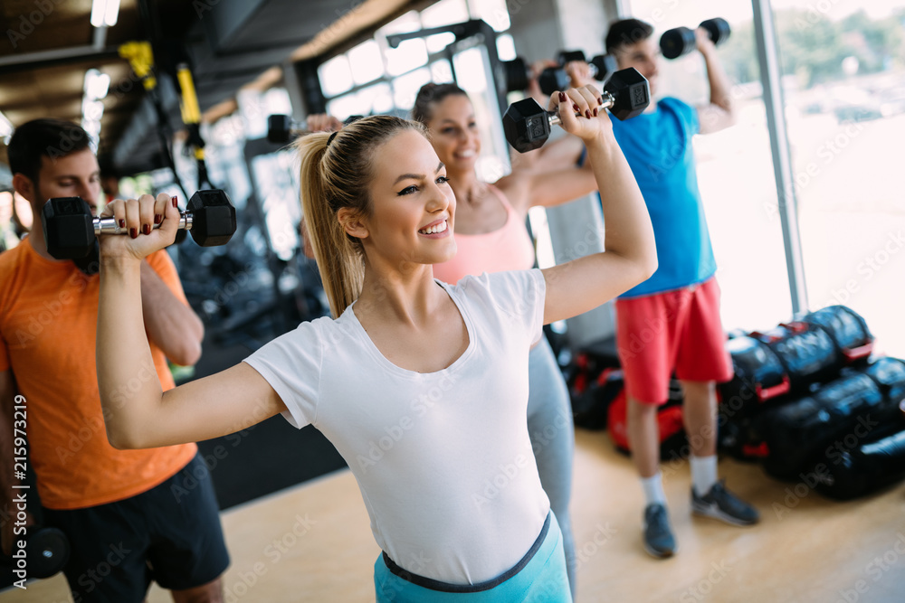 Athletic young woman doing a fitness workout with dumbbells Athletic young woman doing a fitness workout with dumbbells