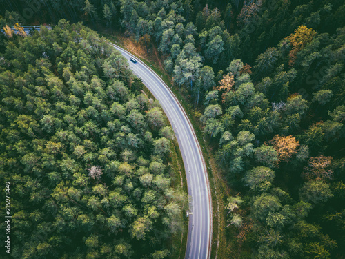 Aerial view of car driving through the forest on country road © A. Aleksandravicius