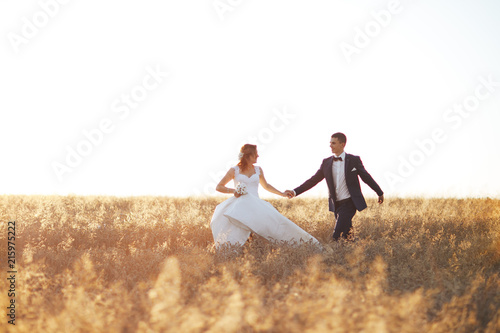Romantic Couple Walks Towards Sunset Holding Hands