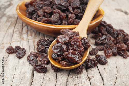 Organic dried Raisins in wood spoon on wooden table, Currant photo