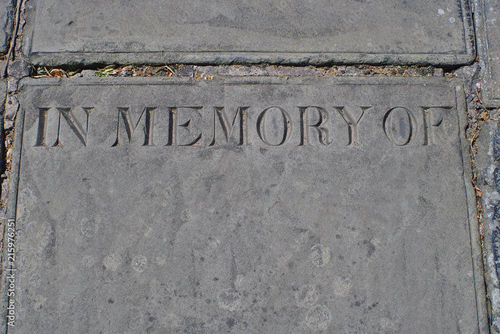 A weathered memorial stone engraved with the words - in memory of - with space below for text. A weathered memorial stone engraved with the words - in memory of - with space below for text.