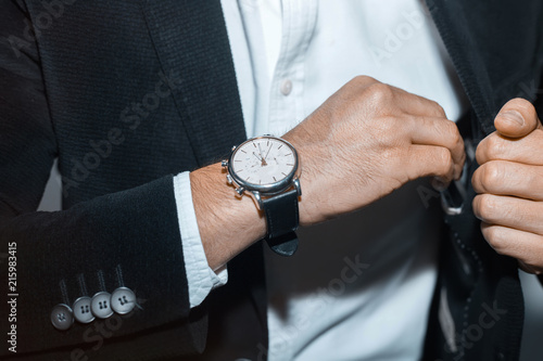 closeup fashion image of luxury watch on wrist of man.body detail of a business man.Man's hand in a grey shirt with cufflinks. Tonal correction 
