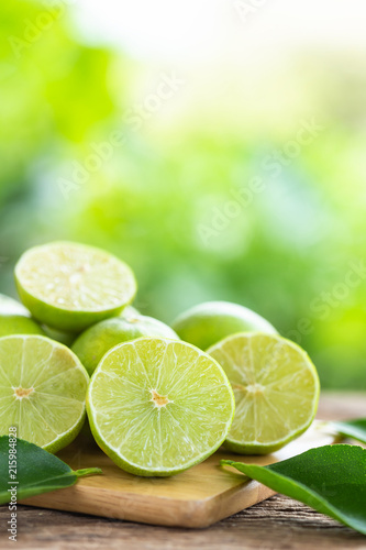 Slice green fresh lemon on wooden table background