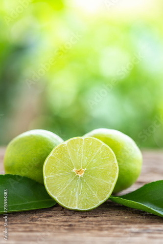 Slice green fresh lemon on wooden table background