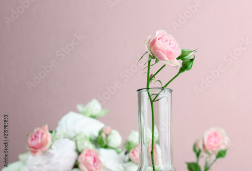 Flower arrangement with summer roses on a pink background