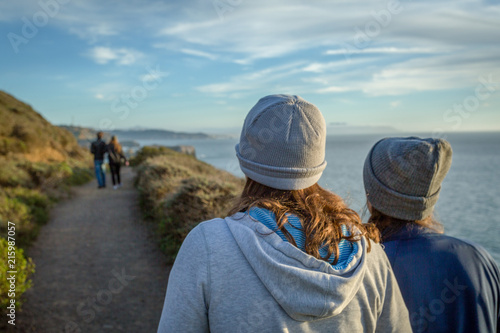 Two women walking a coastline trail
