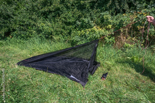 Mesh Zelt in Wiese wird aufgebaut von Hand