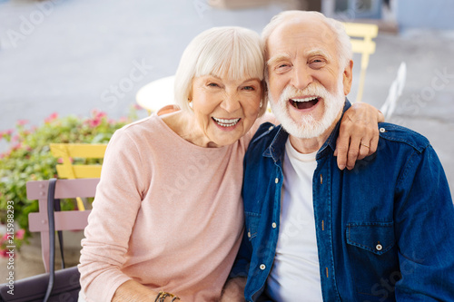 Young inside. Cheerful senior couple laughing and looking at camera