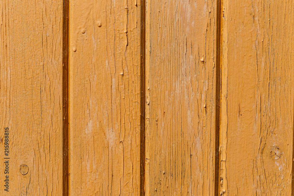 Yellow wooden wall. Old shabby wooden planks with cracked color paint. Background. Texture wood. Yellow wooden wall. Old shabby wooden planks with cracked color paint. Background. Texture wood.