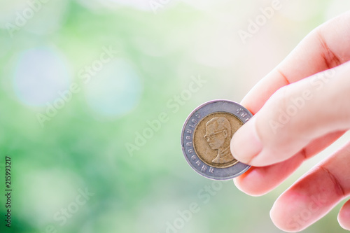 Hand holding a coin, 10 Bah...