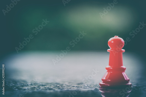 Red chess pawn on dark tone...
