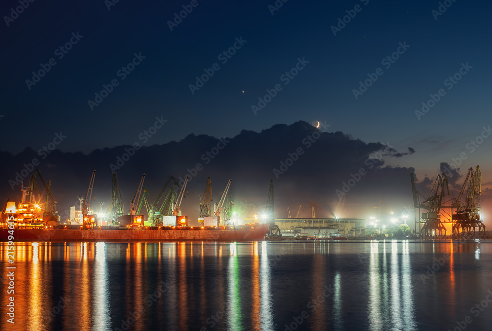 Industrial cranes and cargo ships in Varna port, Bulgaria at sunset
