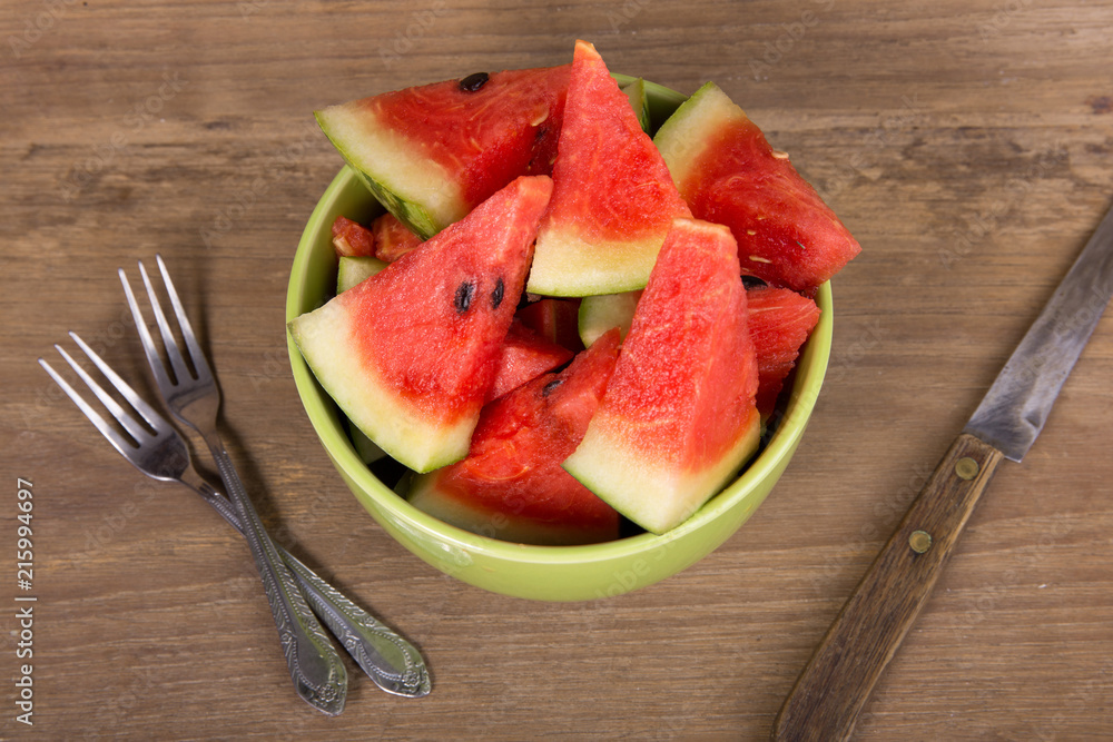 slices of watermelon on brown wooden background slices of watermelon on brown wooden background