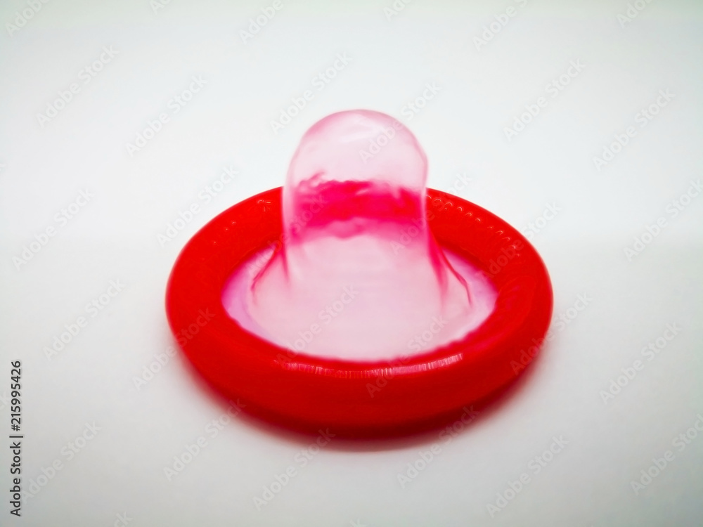 Medication and healthcare concept. Red condom, for birth control. Abortion problem concept and protect Sexually transmitted diseases. Isolated on white background, selective focus and copy space. Medication and healthcare concept. Red condom, for birth control. Abortion problem concept and protect Sexually transmitted diseases. Isolated on white background, selective focus and copy space.