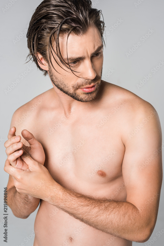 portrait of thoughtful shirtless man with stylish hairstyle isolated on grey