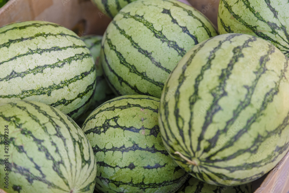 Pile of fresh ripe watermelons lying in wooden boxes in fruit and vegetable department of supermarket. Pile of fresh ripe watermelons lying in wooden boxes in fruit and vegetable department of supermarket.