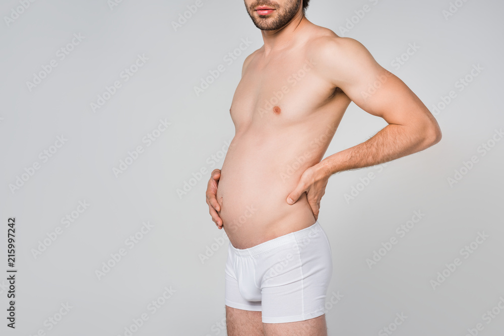 partial view of man in white underwear with swollen stomach isolated on grey