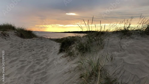 Moving steadyshot of a colorful sunset by a beach in sweden. photo