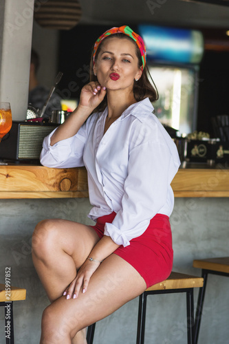 Beauty young woman portrait with a glass drinking a cocktail at a bar