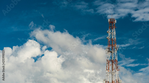 Telecommunication antenna on the top of the telecommunications service provider's building with clouds and blue sky background in technology concept.
