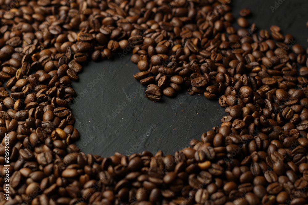 Coffee grains on a dark background. A delicious fragrant coffee of the best varieties. Coffee texture. Coffee beans background.Heart of coffee Coffee grains on a dark background. A delicious fragrant coffee of the best varieties. Coffee texture. Coffee beans background.Heart of coffee
