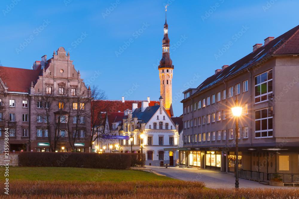 Fototapeta premium Beautiful illuminated street with Town Hall in Medieval Old Town on the morning blue hour, Tallinn, Estonia